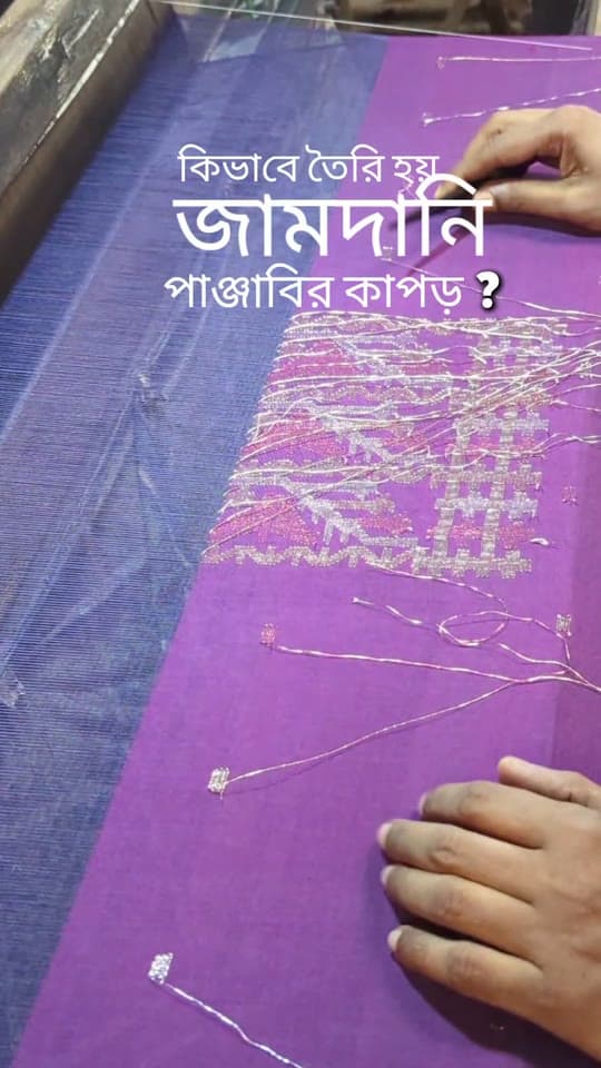 তাঁতে বেগুনি কাপড়ে হাতে সুতো গুঁজে জামদানির নকশা তোলা হচ্ছে